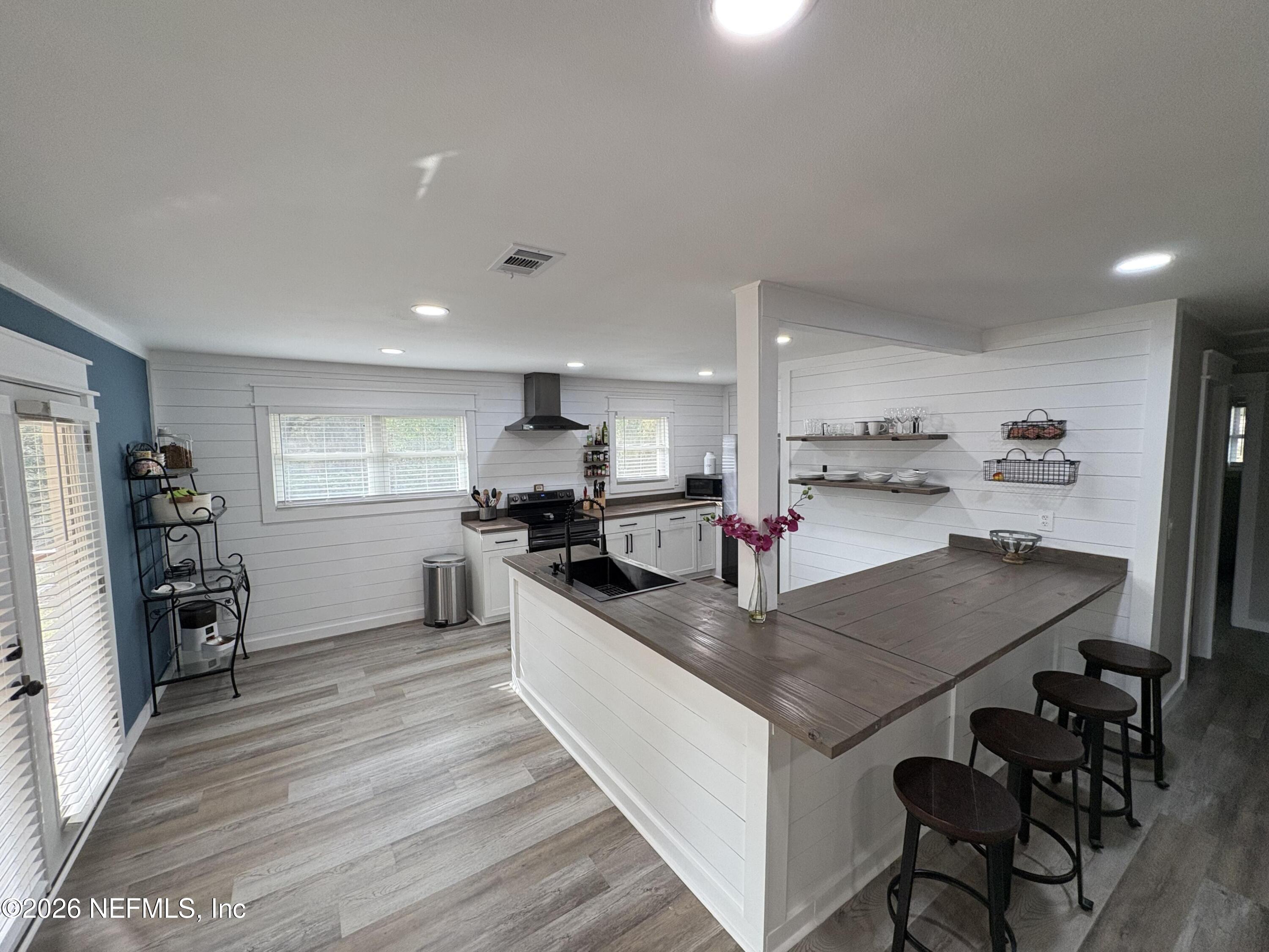 165 Fulton Road Palatka, FL 32177 - Photo 11 of 26 a kitchen with stainless steel appliances granite countertop a stove top oven a sink dishwasher and a refrigerator with wooden floor
