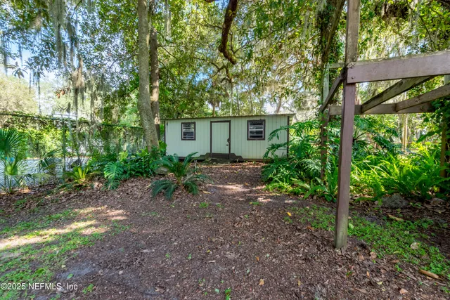 an aerial view of residential houses with outdoor space and lake view