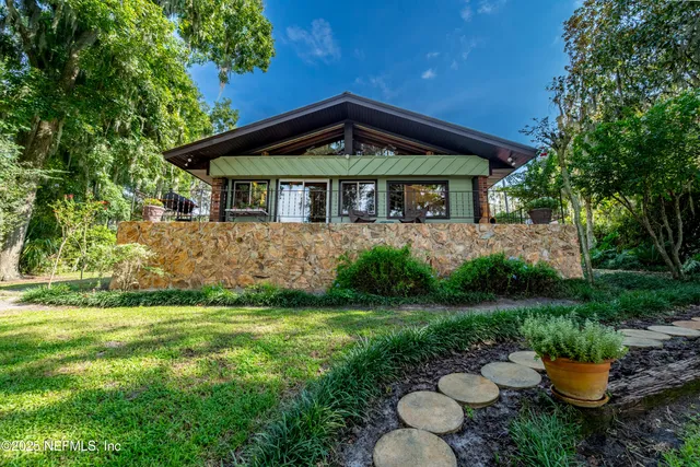 a living room with stainless steel appliances granite countertop furniture and a wooden floor
