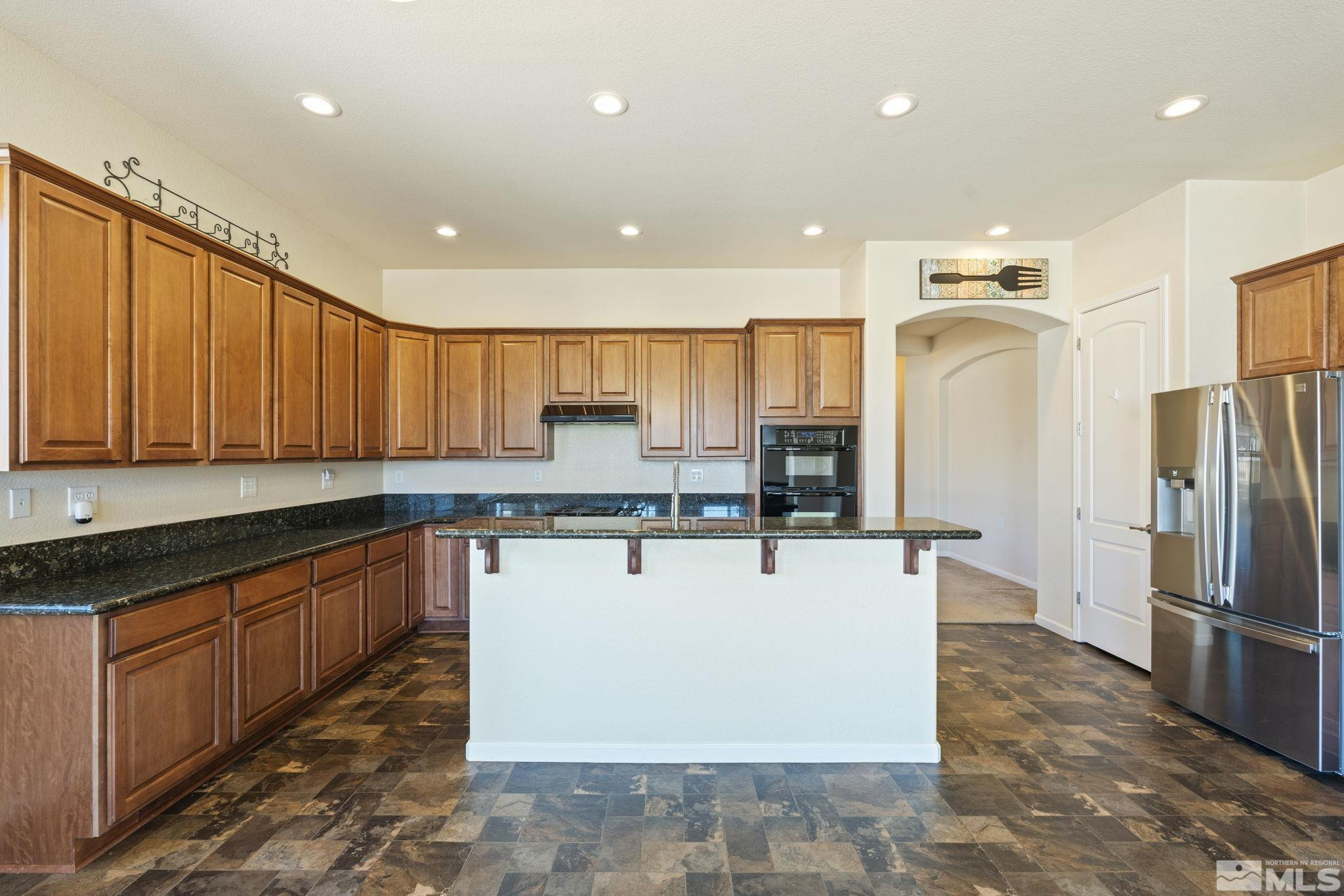 10295 Cavalry Circle Reno, NV 89521 - Photo 12 of 40 a kitchen with stainless steel appliances granite countertop a refrigerator a stove and a sink