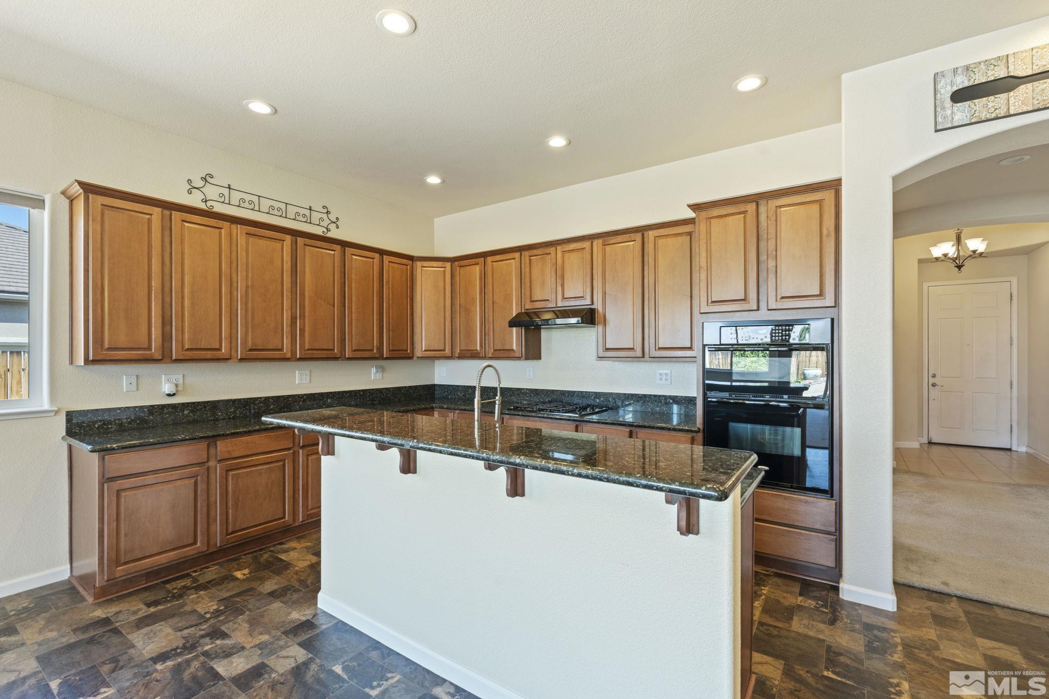 10295 Cavalry Circle Reno, NV 89521 - Photo 15 of 40 a large kitchen with stainless steel appliances granite countertop a sink and cabinets