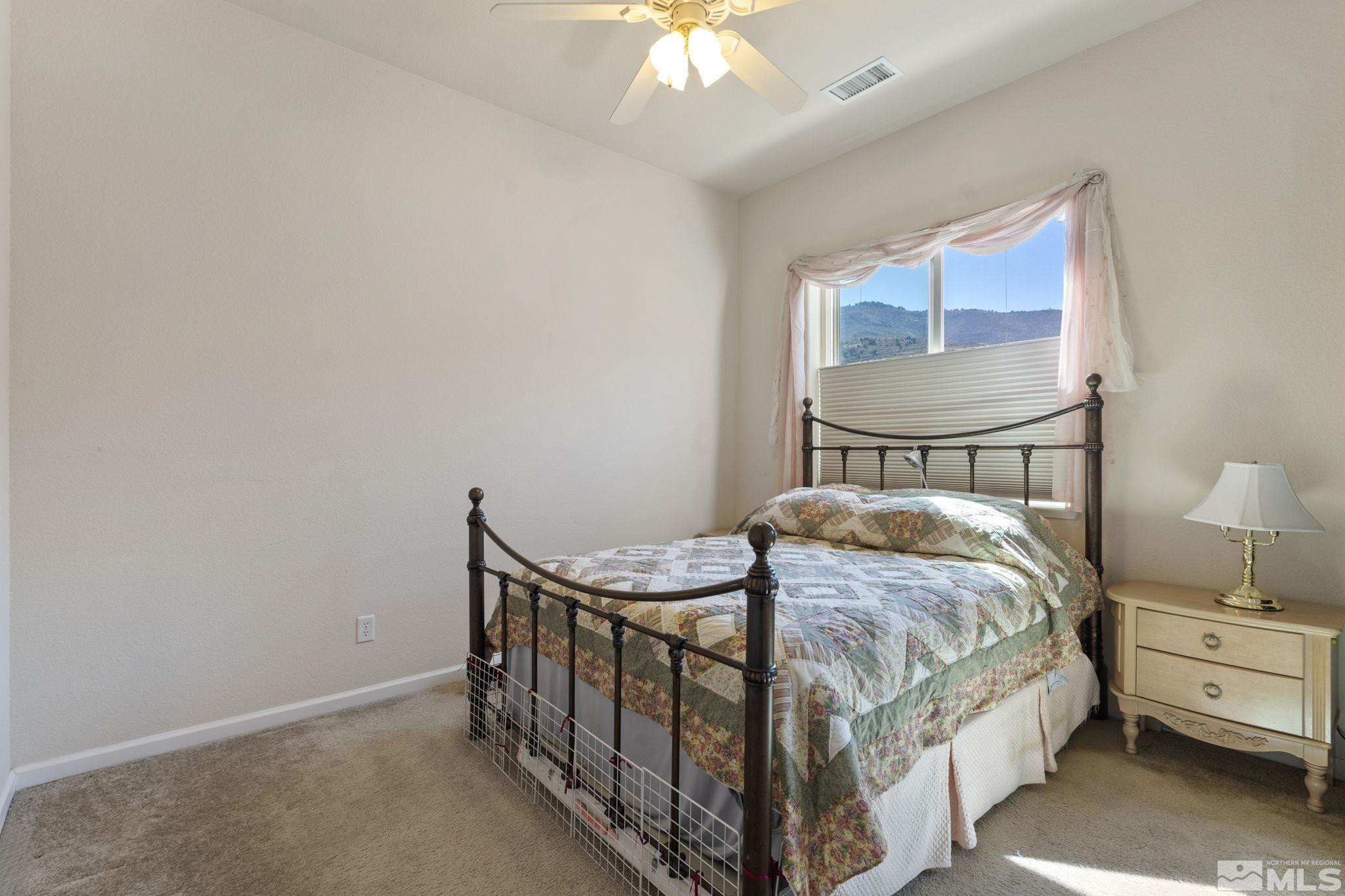 10295 Cavalry Circle Reno, NV 89521 - Photo 28 of 40 a bedroom with a bed and a chandelier