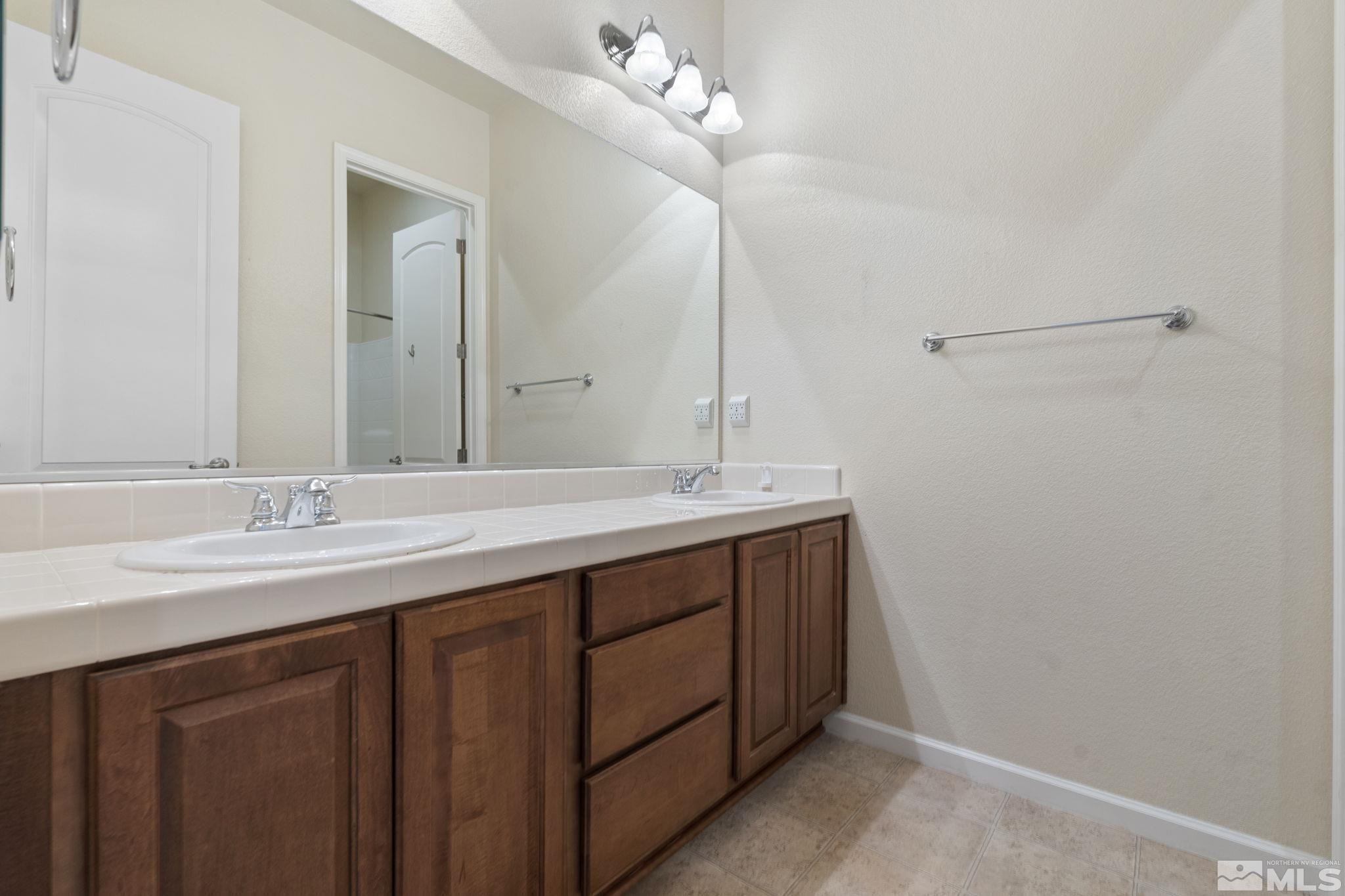 10295 Cavalry Circle Reno, NV 89521 - Photo 29 of 40 a bathroom with a double vanity sink and a mirror