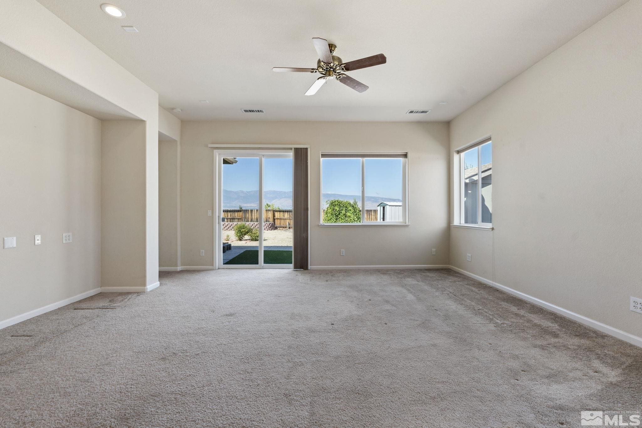10295 Cavalry Circle Reno, NV 89521 - Photo 7 of 40 a view of an empty room with a window and a kitchen
