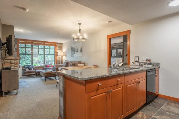 a kitchen with granite countertop a sink stove and cabinets