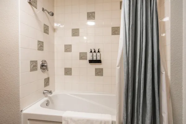 a bathroom with bathtub and mirror