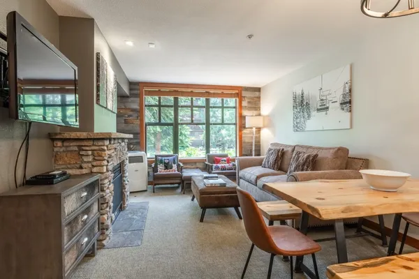 a living room with furniture a flat screen tv and a large window