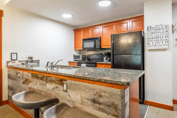 a kitchen with stainless steel appliances granite countertop a sink refrigerator and cabinets