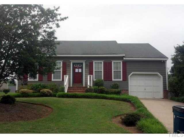 a front view of a house with a yard and trees