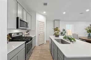 8027 Milam Lane Rosharon, TX 77583 - Photo 12 of 18 a kitchen with kitchen island granite countertop stainless steel appliances a sink a stove top oven a counter space and cabinets