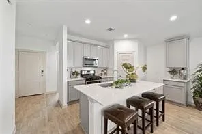 a kitchen with sink a refrigerator and chairs