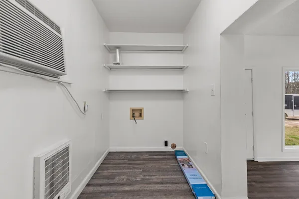 a view of a hallway with wooden floor and entryway