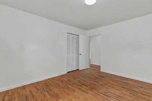 a view of empty room with wooden floor