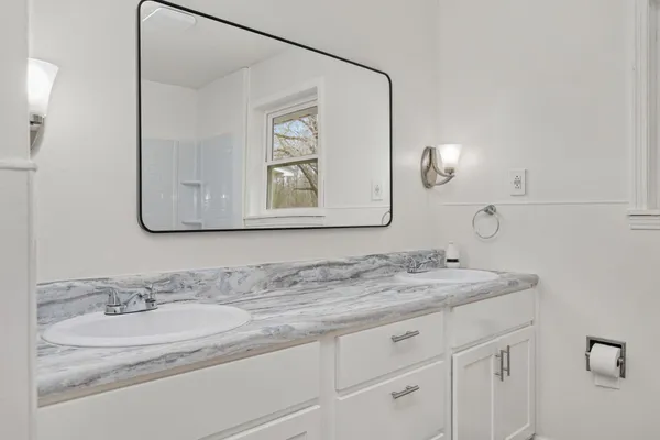 a bathroom with a granite countertop sink mirror and vanity