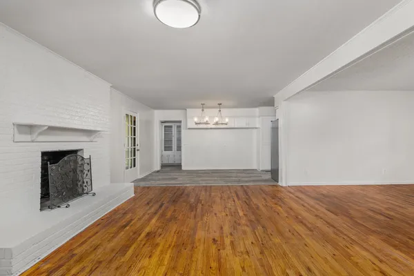 a view of empty room with wooden floor and fireplace