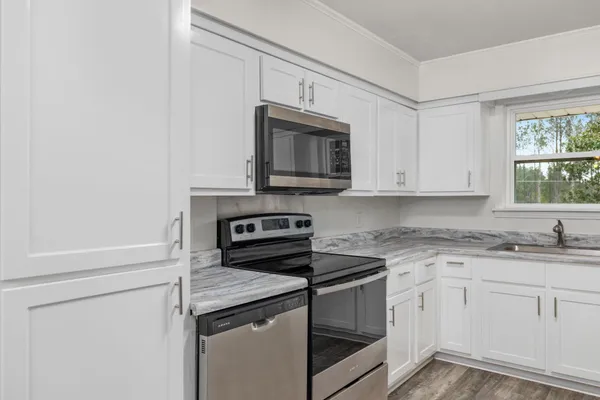 a kitchen with granite countertop white cabinets and white appliances