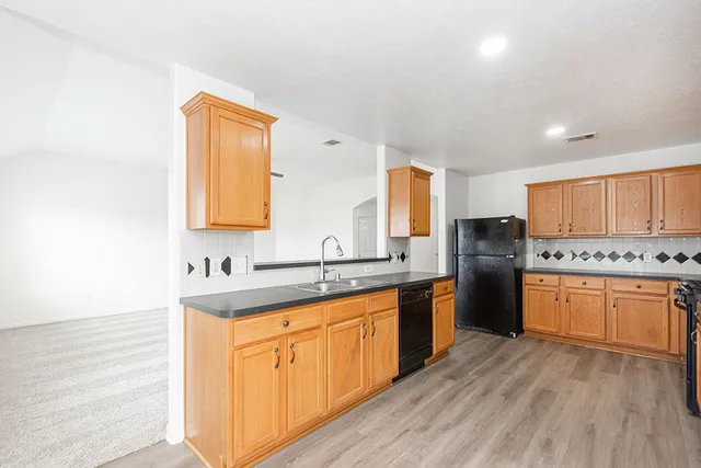 a kitchen with stainless steel appliances granite countertop a sink stove and refrigerator