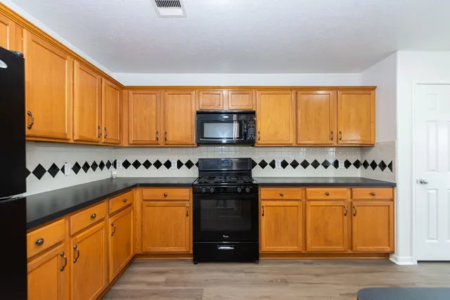 a kitchen with stainless steel appliances granite countertop a stove and a refrigerator