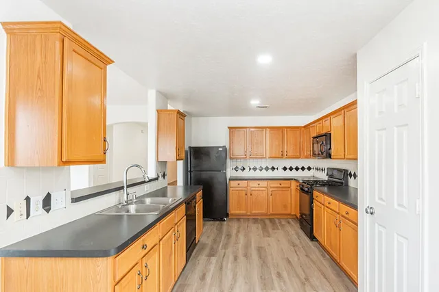 a kitchen with stainless steel appliances granite countertop a sink stove and refrigerator