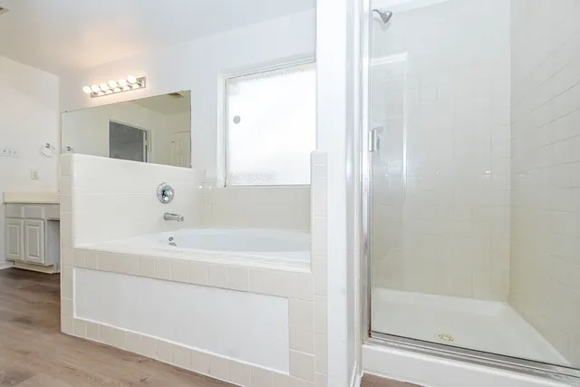 a bathroom with a double vanity sink mirror and bathtub
