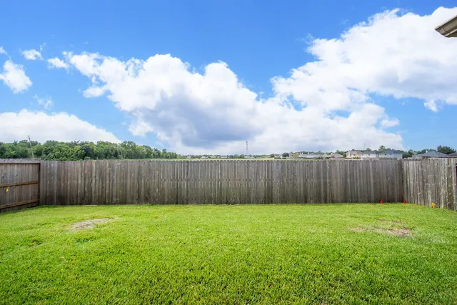 a view of backyard with wooden fence