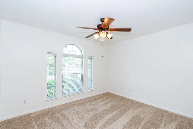 a view of a room with a window and a ceiling fan