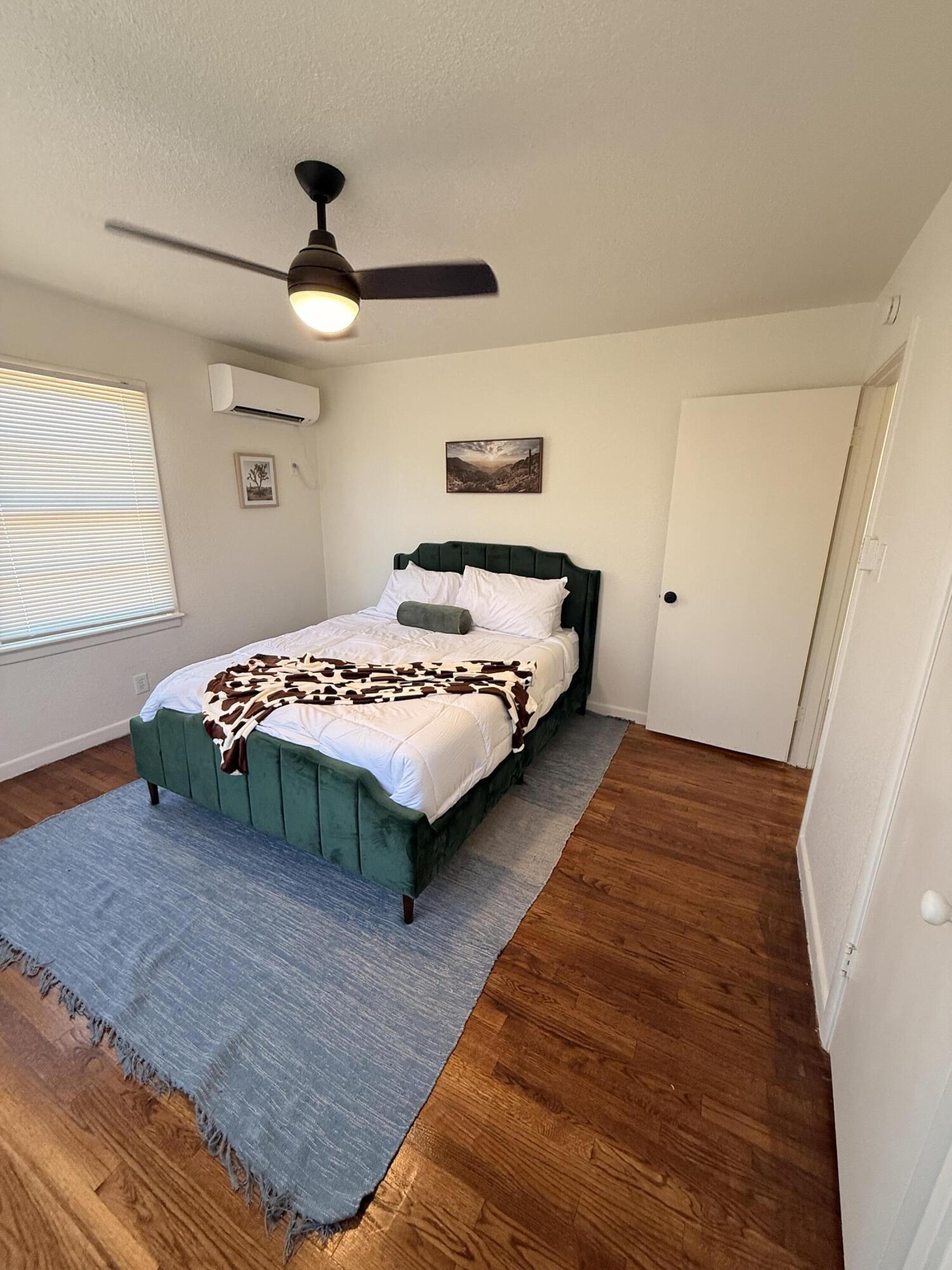 4601 43rd Street Lubbock, TX 79414 - Photo 6 of 12 a bedroom with a bed and a large mirror
