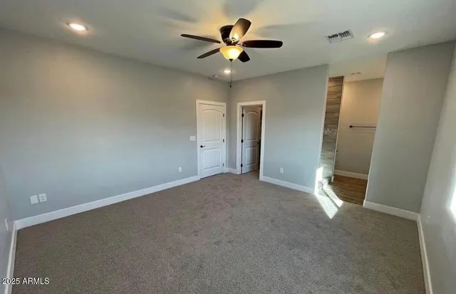 an empty room and chandelier fan