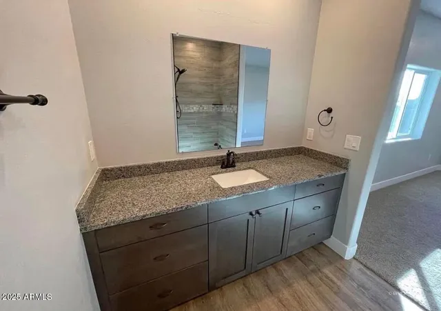 a bathroom with a granite countertop sink and a mirror