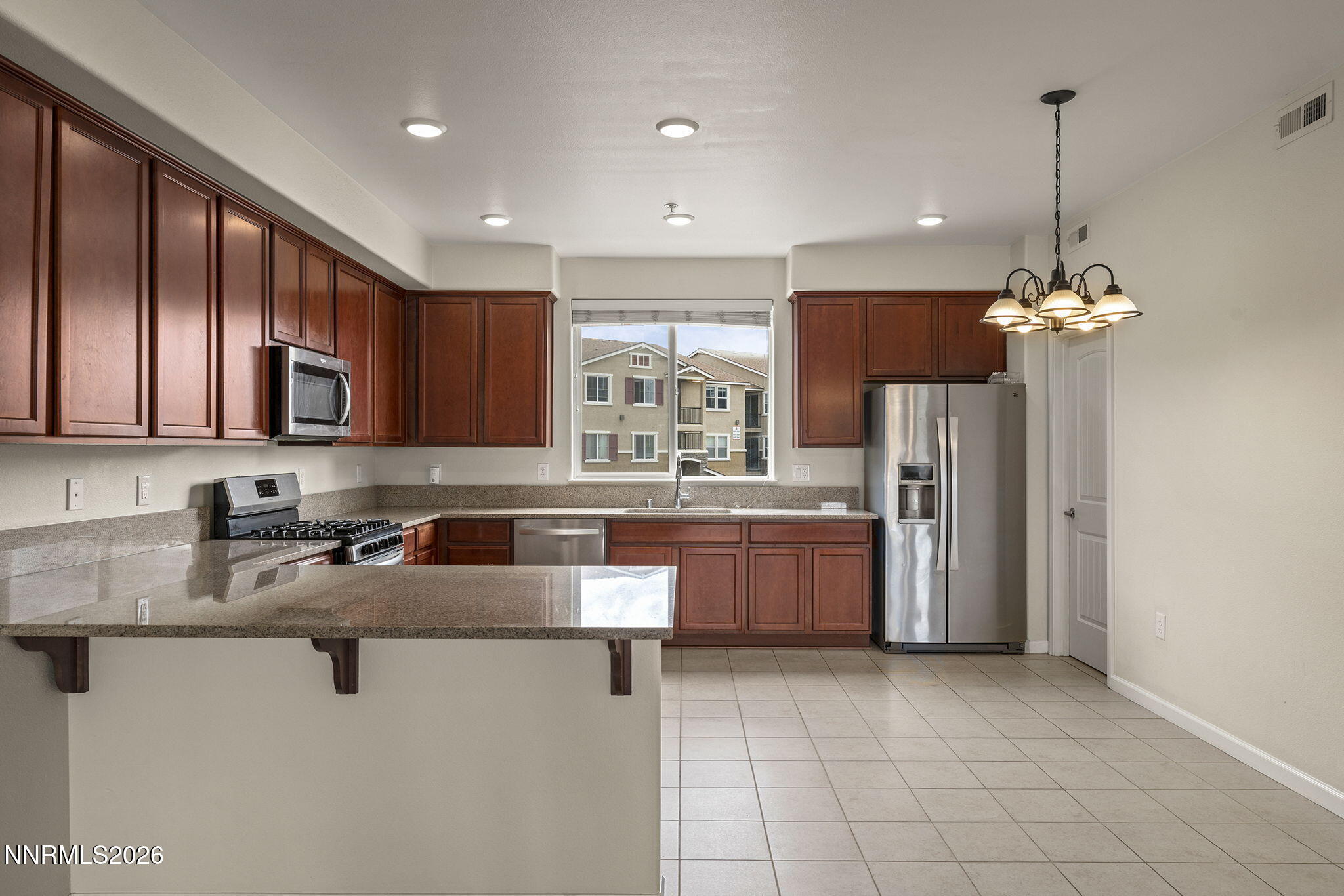 2490 Eastshore Place, Unit 104 Reno, NV 89509 - Photo 9 of 29 a kitchen with stainless steel appliances granite countertop a sink a stove and a refrigerator