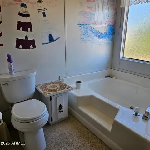 a bathroom with a toilet sink and mirror