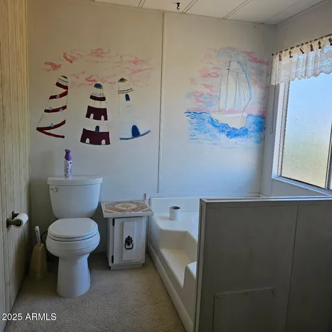 a white toilet sitting next to a white sink and vanity