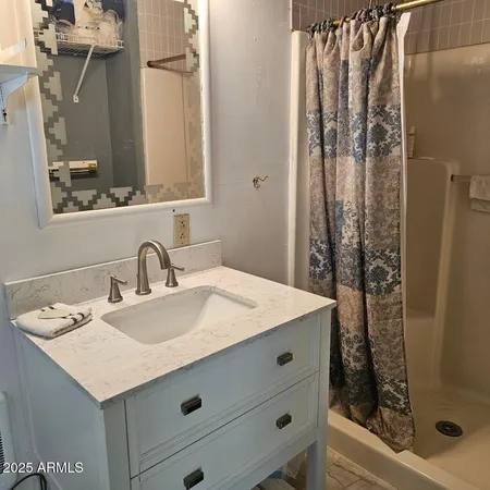 a bathroom with a sink vanity granite and a mirror
