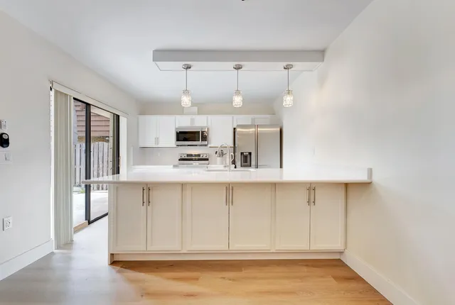 a kitchen with kitchen island white cabinets and refrigerator
