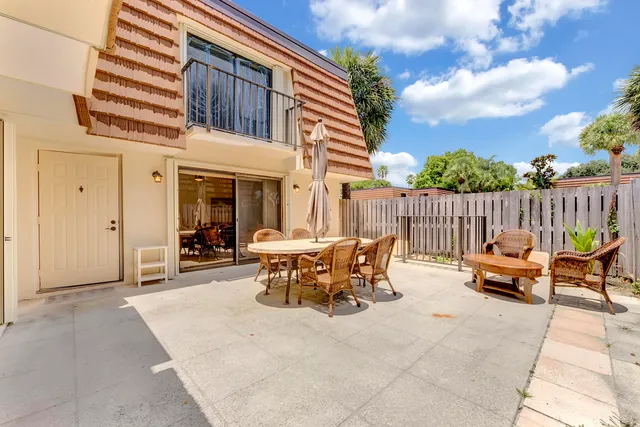 a view of a patio with table and chairs with wooden fence