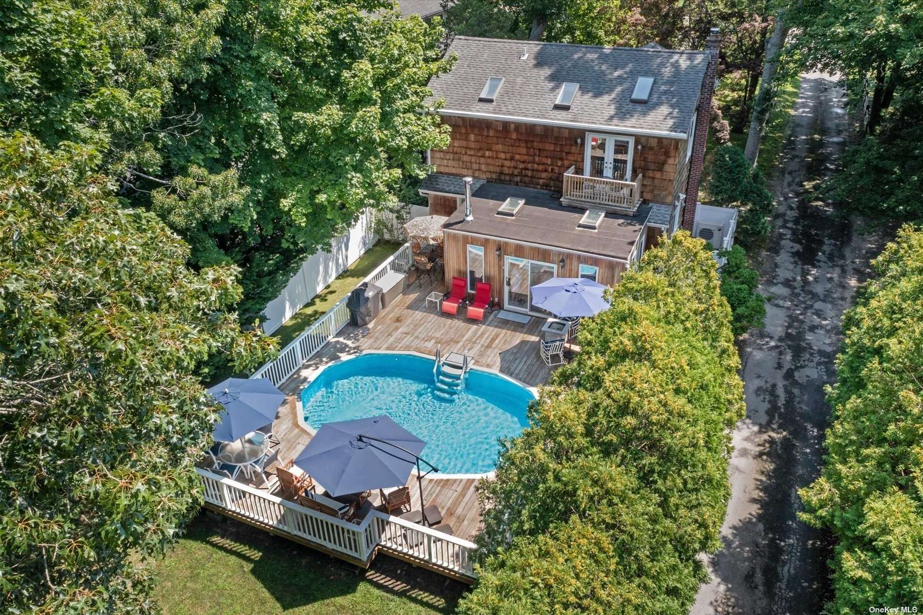 an aerial view of a house with a swimming pool a yard and a large tree