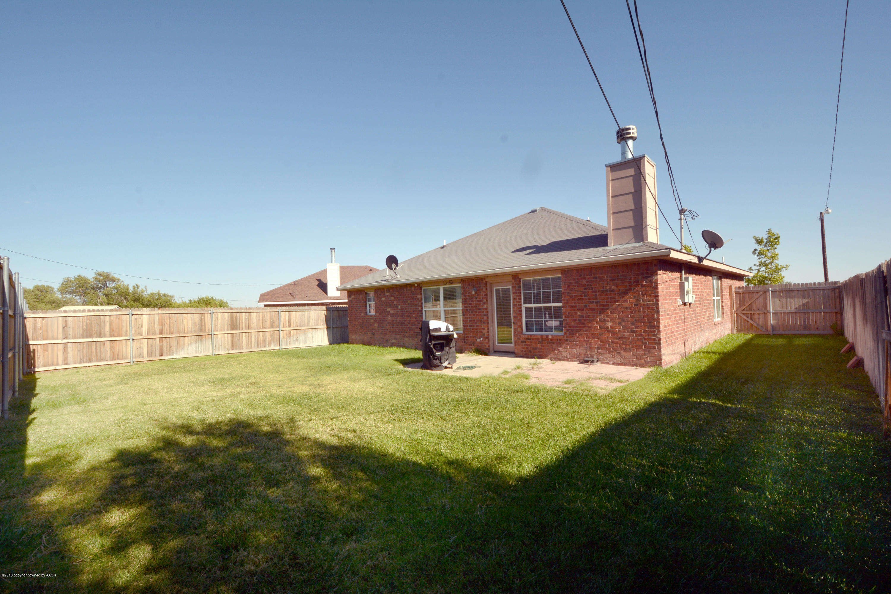 4702 Capulin Lane Amarillo, TX 79110 - Photo 23 of 24 a view of a big yard with plants and a building
