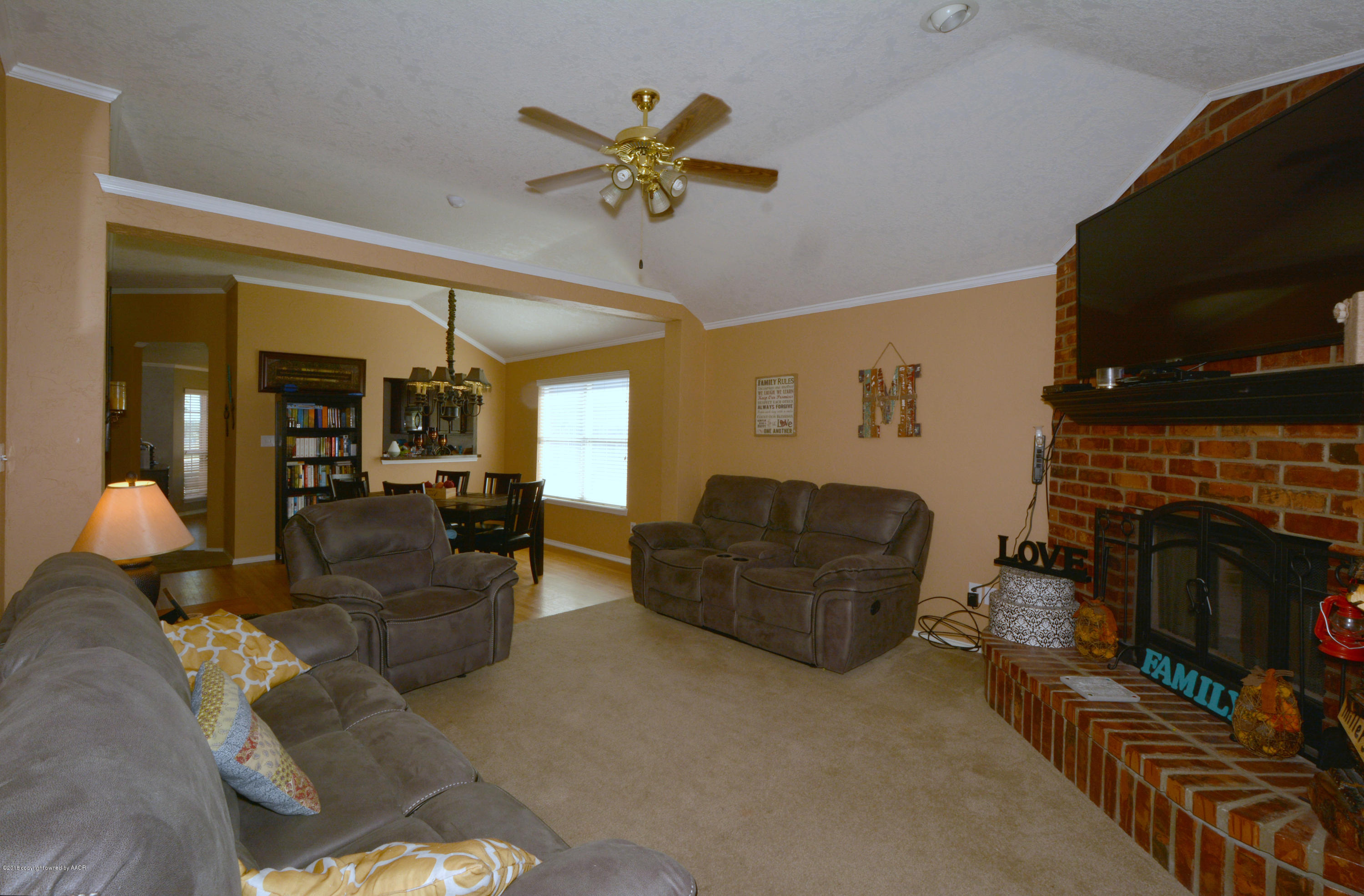 4702 Capulin Lane Amarillo, TX 79110 - Photo 5 of 24 a living room with furniture a fireplace and a flat screen tv