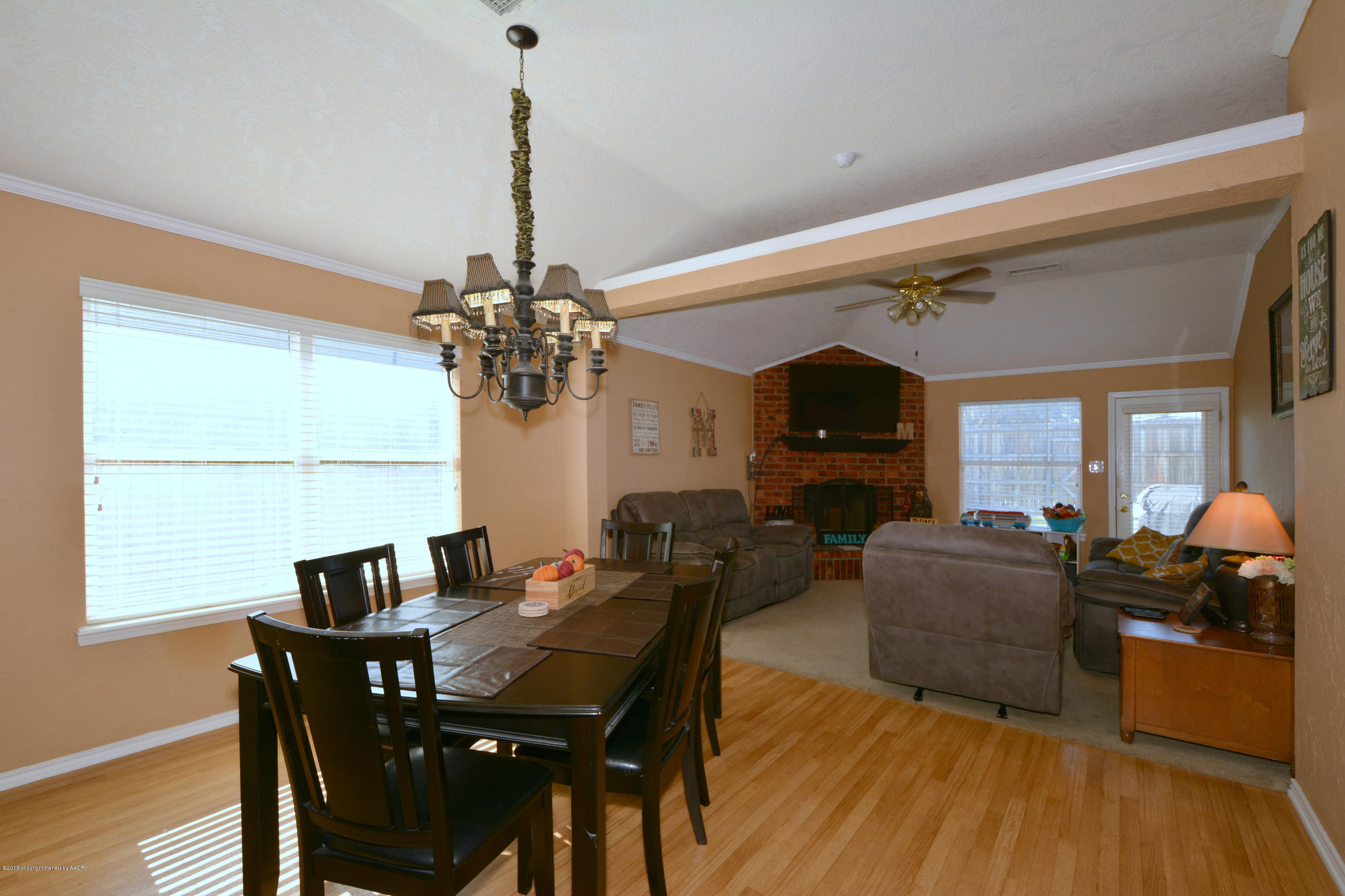 4702 Capulin Lane Amarillo, TX 79110 - Photo 10 of 24 a living room with furniture a chandelier and a flat screen tv