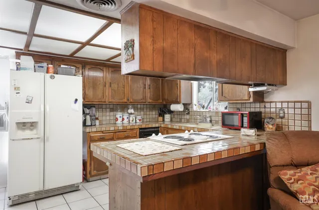 a kitchen with granite countertop a sink a stove and a refrigerator