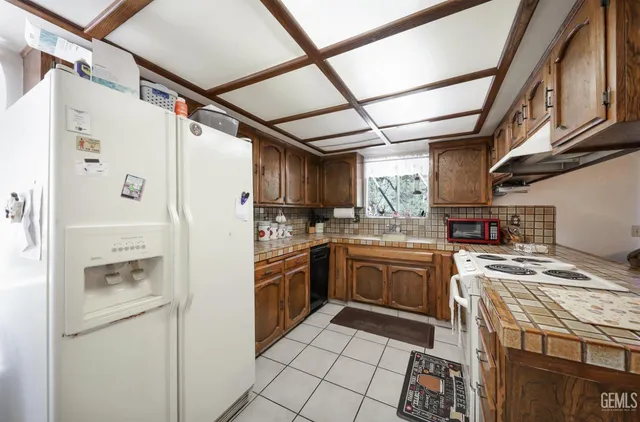 a kitchen with stainless steel appliances granite countertop a refrigerator and a stove