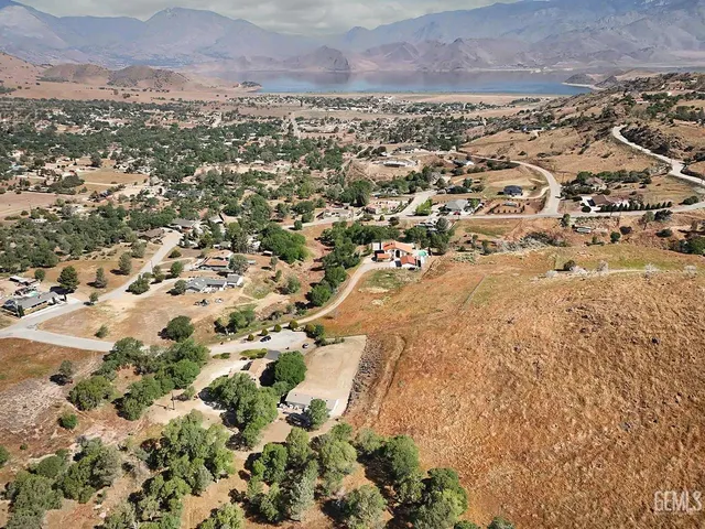 an aerial view of residential house with yard and mountain view in back