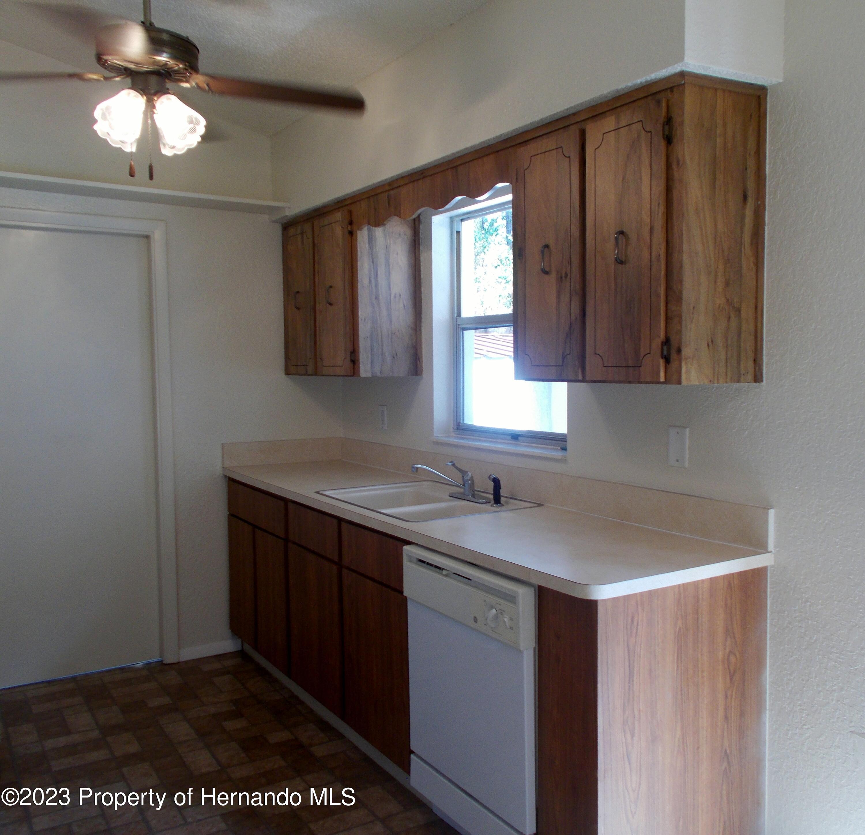 10340 Musa Road Spring Hill, FL 34608 - Photo 5 of 16 a kitchen with a sink a counter space and cabinets