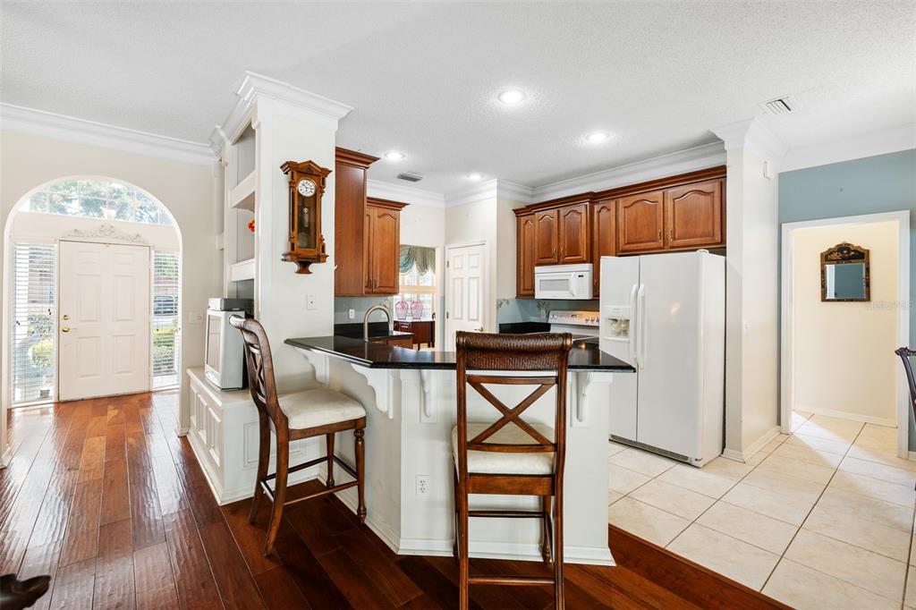4906 Willow Ridge Terrace Valrico, FL 33596 - Photo 11 of 67 a kitchen with stainless steel appliances a refrigerator a stove top oven and a dining table with wooden floor
