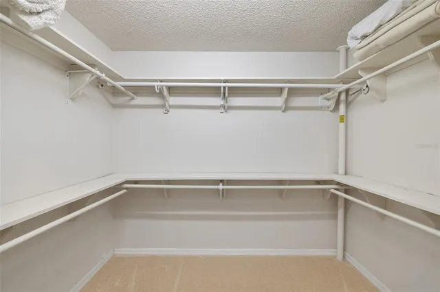 a bedroom with a bed book shelf and a window