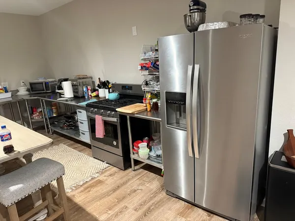 a living room with furniture a flat screen tv and white appliances