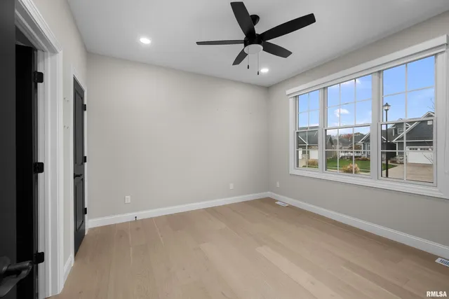 a living room with stainless steel appliances kitchen island granite countertop lots of white cabinets a refrigerator and a sink