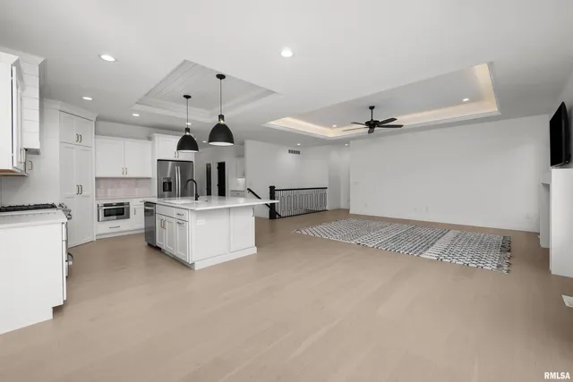 a kitchen with kitchen island granite countertop a sink a counter top space and cabinets