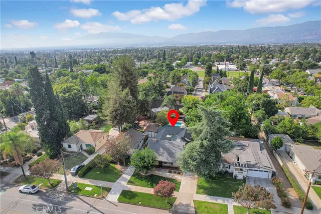 an aerial view of residential houses with outdoor space and trees