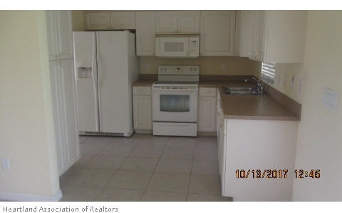 4441 Loquat Road Sebring, FL 33875 - Photo 2 of 6 a kitchen with a stove and a refrigerator